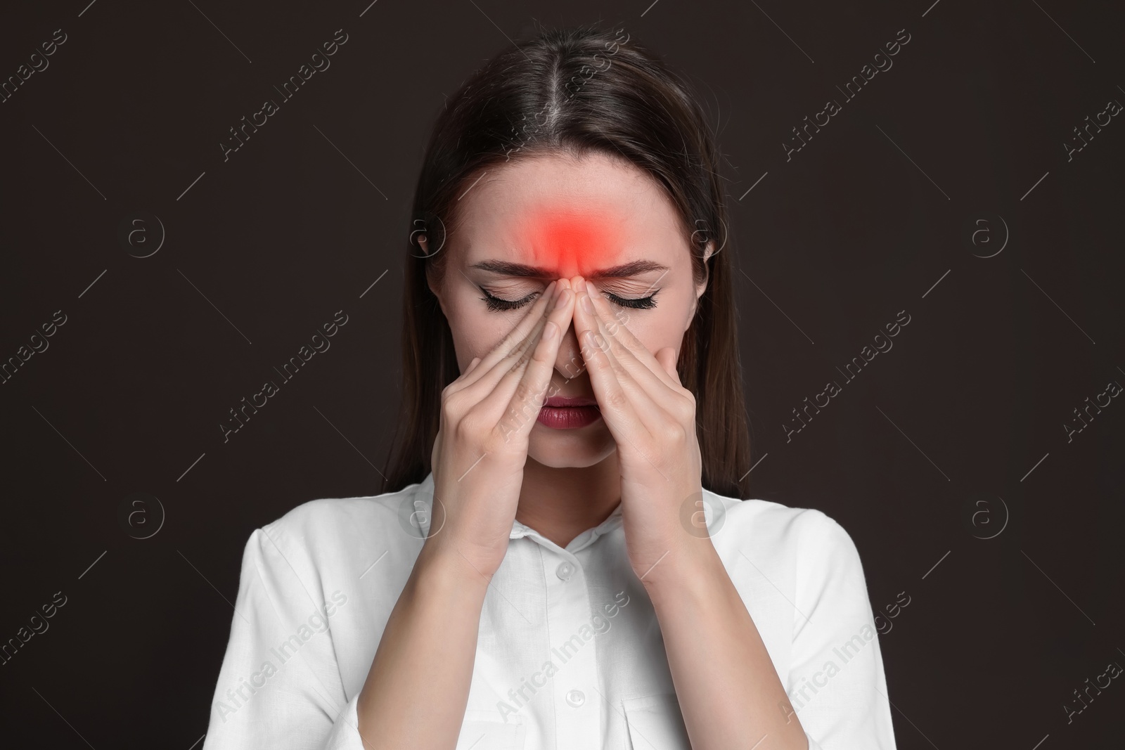 Image of Young woman suffering from headache on dark brown background