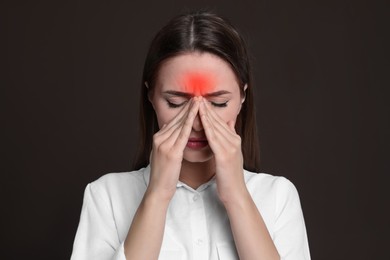 Image of Young woman suffering from headache on dark brown background