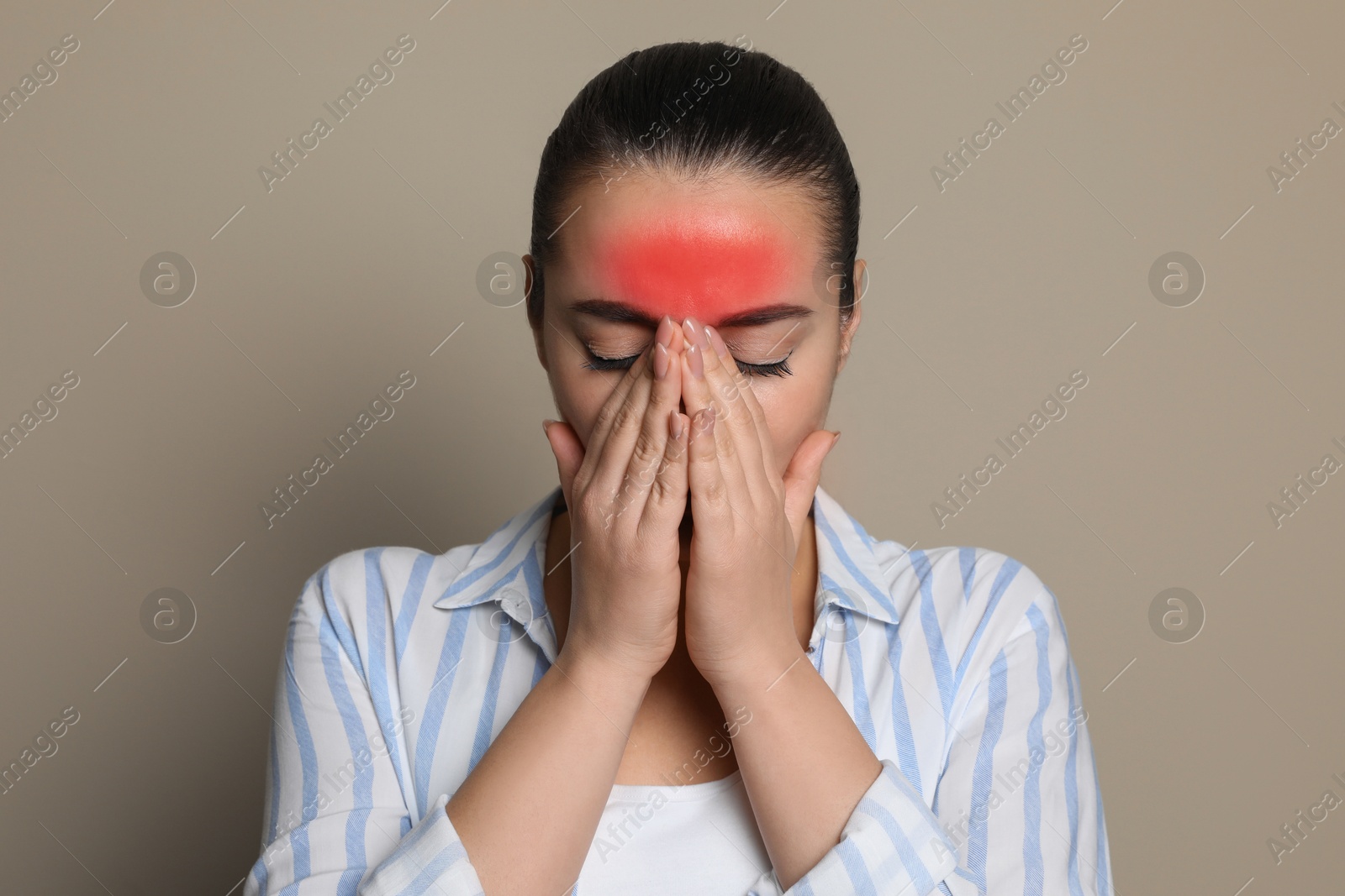 Image of Young woman suffering from headache on beige background