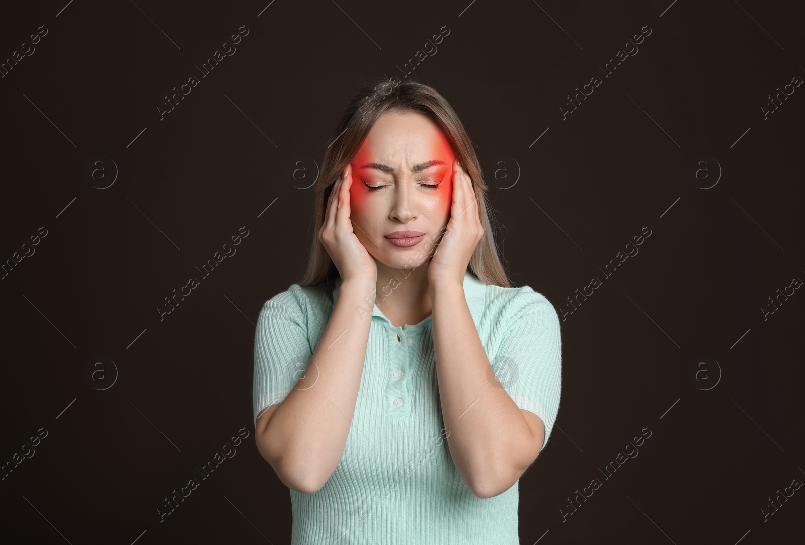 Image of Young woman suffering from headache on dark brown background