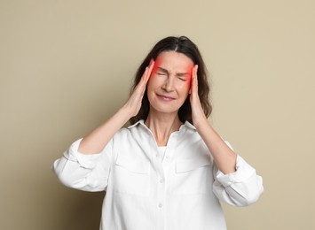 Image of Woman suffering from headache on beige background