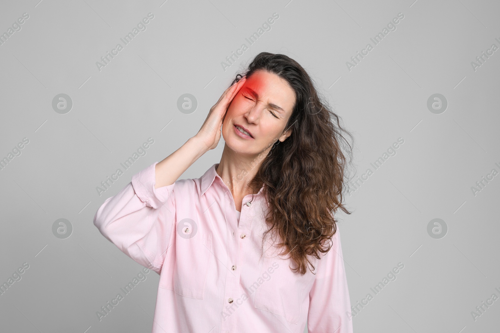 Image of Woman suffering from headache on grey background