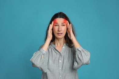 Image of Woman suffering from headache on light blue background