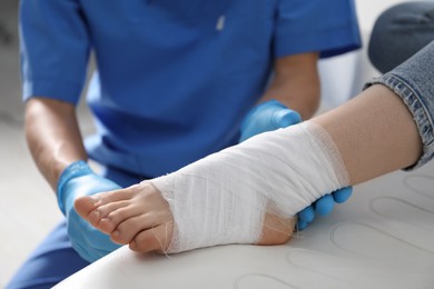 Photo of Doctor bandaging patient's foot in clinic, closeup