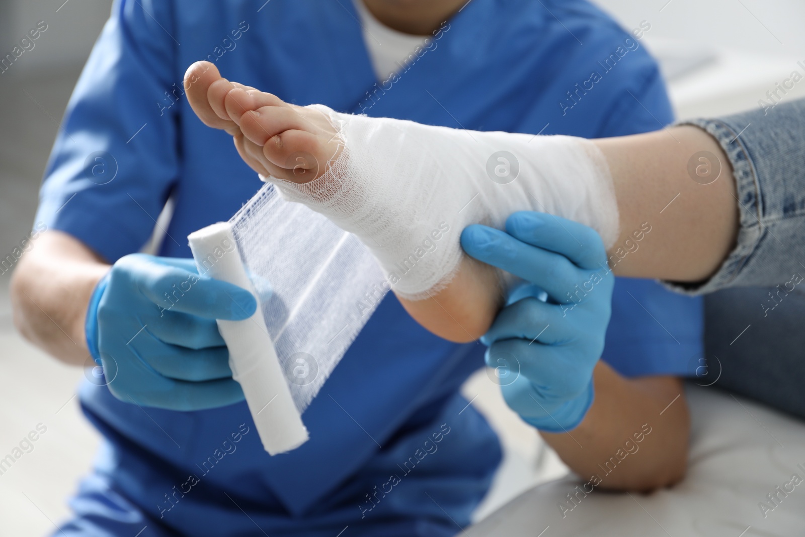 Photo of Doctor bandaging patient's foot in clinic, closeup