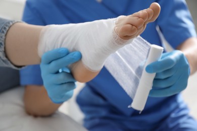 Photo of Doctor bandaging patient's foot in clinic, closeup