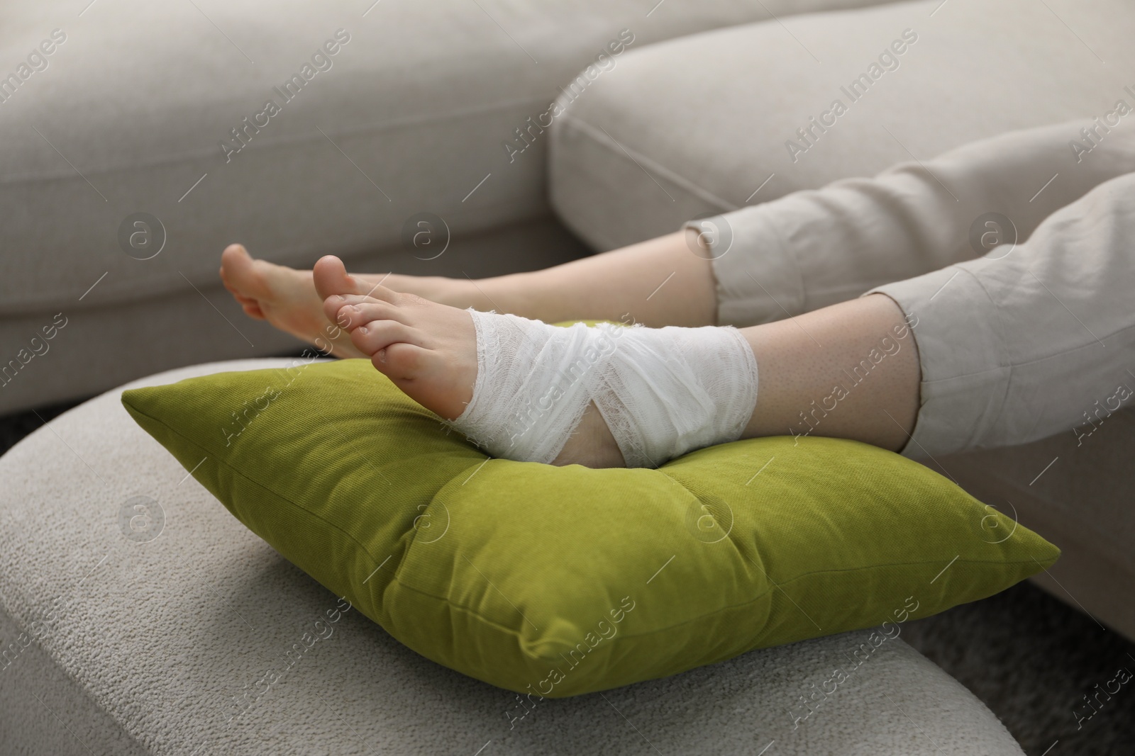 Photo of Woman with medical bandage on her foot at home, closeup