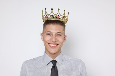 Photo of Handsome man wearing luxury crown on white background