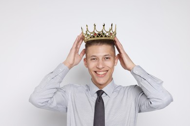 Photo of Handsome man wearing luxury crown on white background