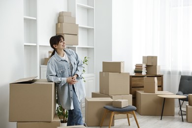 Photo of Moving day. Happy woman with her belongings in new home