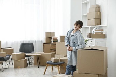 Photo of Moving day. Happy woman with her belongings in new home