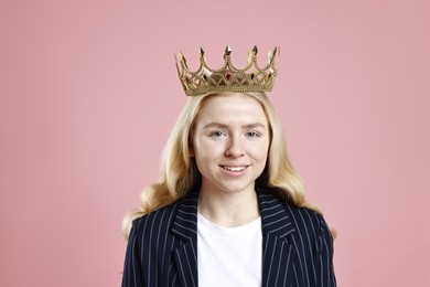 Photo of Smiling businesswoman in elegant crown on dusty pink background