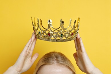 Photo of Woman wearing elegant crown on yellow background, closeup