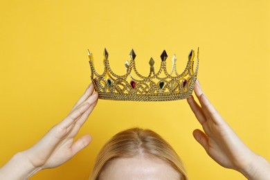 Photo of Woman wearing elegant crown on yellow background, closeup