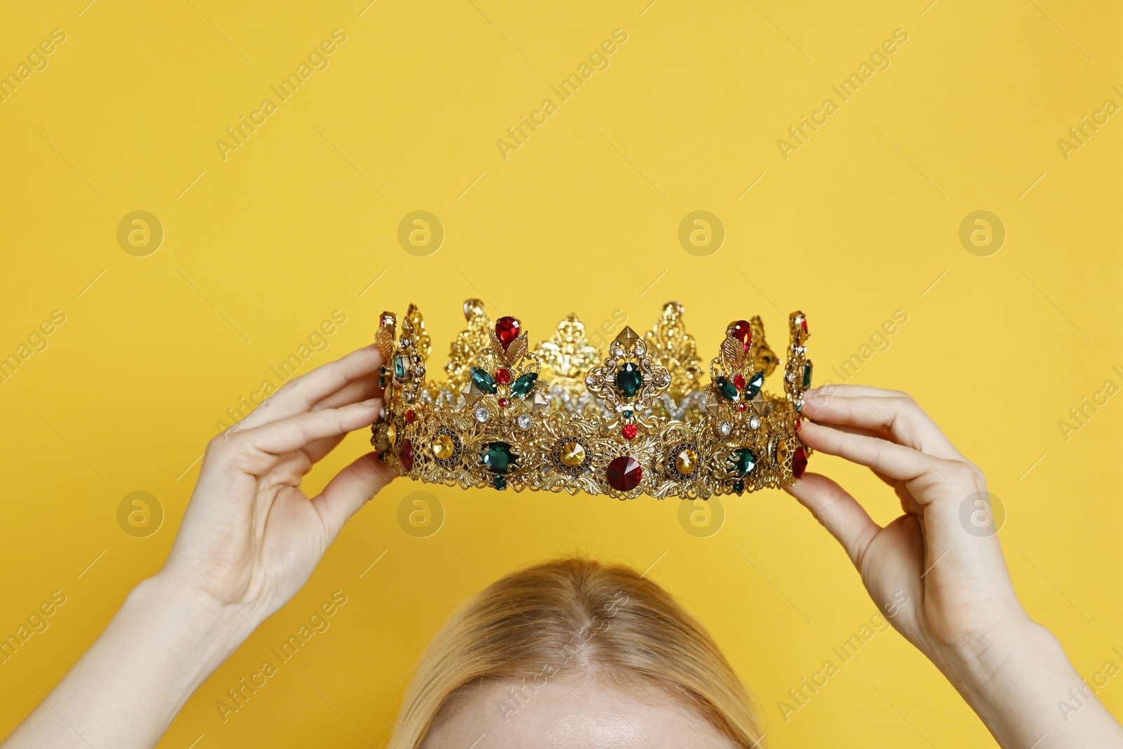 Photo of Woman wearing elegant crown on yellow background, closeup