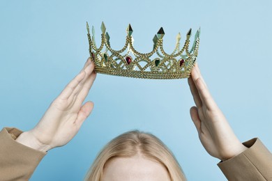 Photo of Woman wearing elegant crown on light blue background, closeup