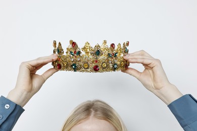 Woman wearing elegant crown on light background, closeup