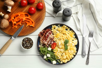 Photo of Tasty brunch. Delicious scrambled eggs, bacon and salad served on white wooden table, flat lay