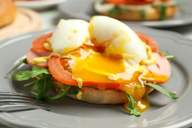 Photo of Tasty brunch. Poached egg, ham, tomato, arugula and bun on table, closeup