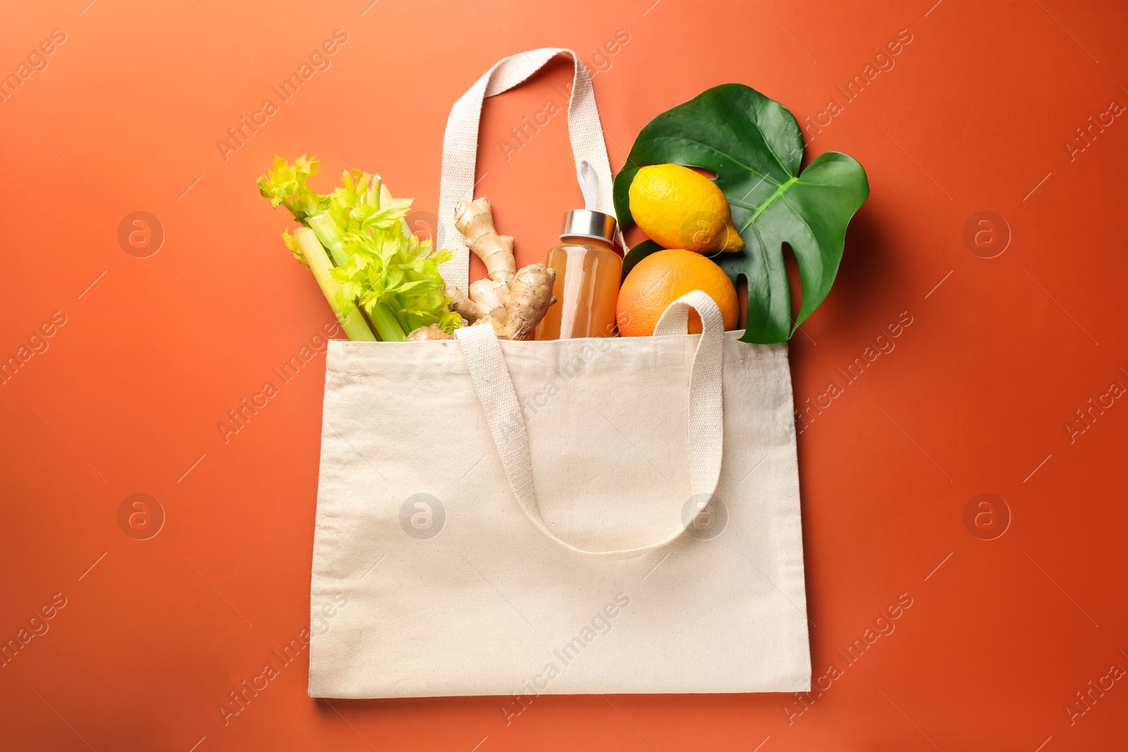 Photo of Shopper bag with products on orange background, top view. Eco friendly lifestyle