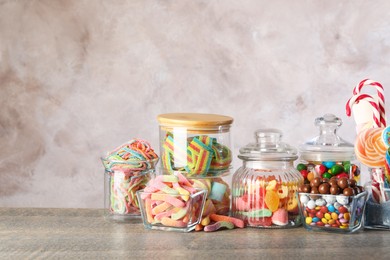 Photo of Candy bar. Many different sweets on wooden table against grey background. Space for text