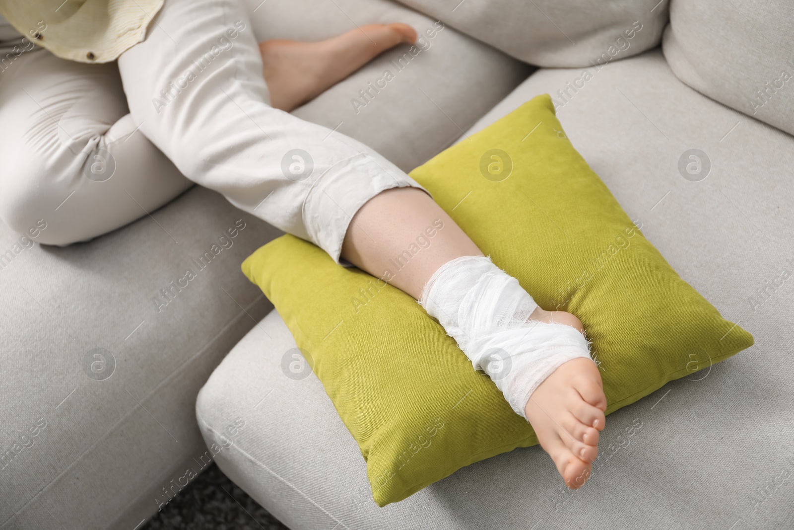 Photo of Woman with medical bandage on her foot at home, closeup