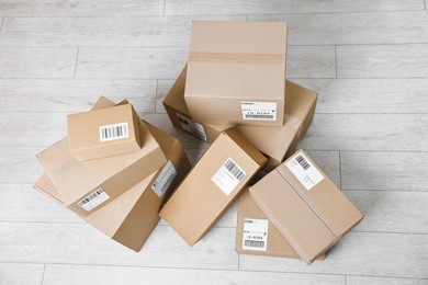 Photo of Cardboard parcel boxes with shipping labels on floor indoors, top view