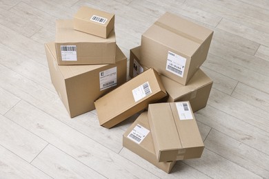 Cardboard parcel boxes with shipping labels on floor indoors