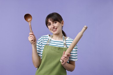 Photo of Woman with rolling pin and ladle on violet background