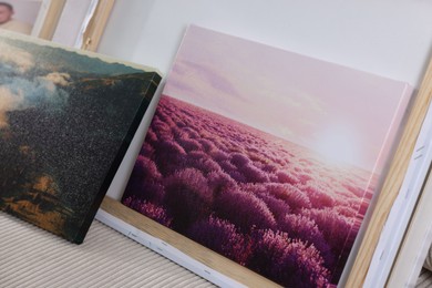 Canvas with different printed photos on sofa indoors, closeup