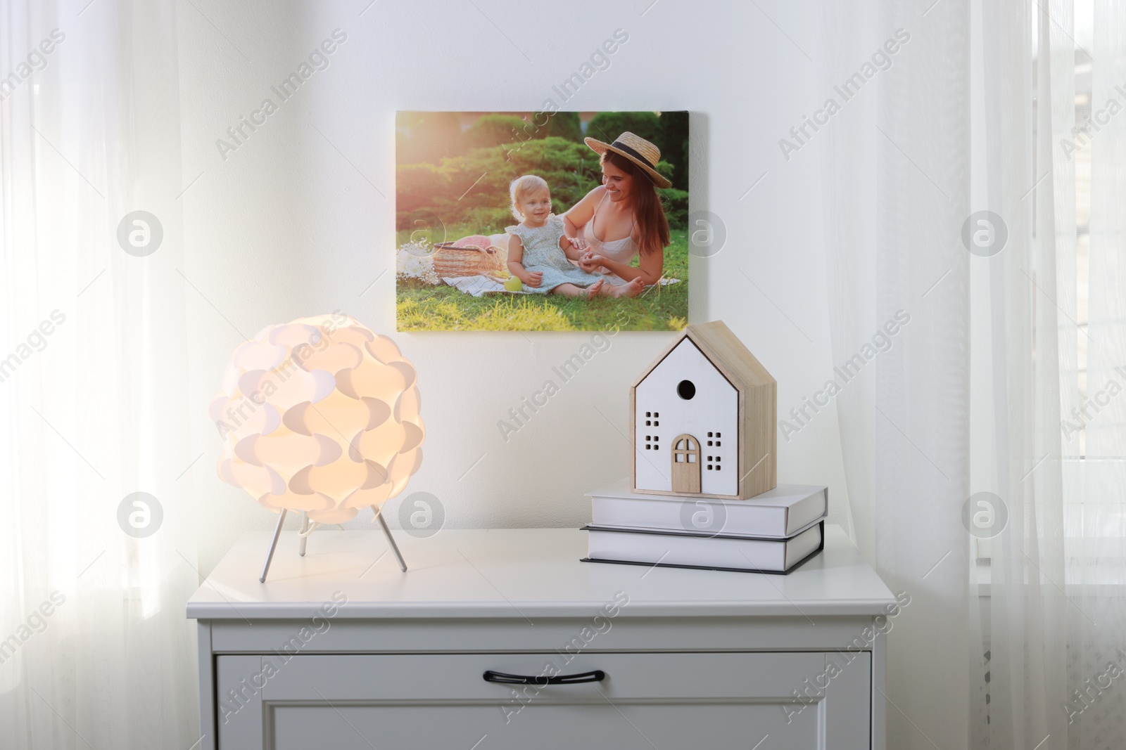 Photo of Canvas with printed photo of happy mother and her little daughter on white wall indoors