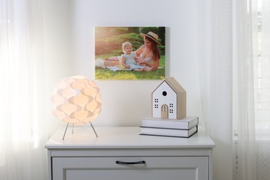 Canvas with printed photo of happy mother and her little daughter on white wall indoors