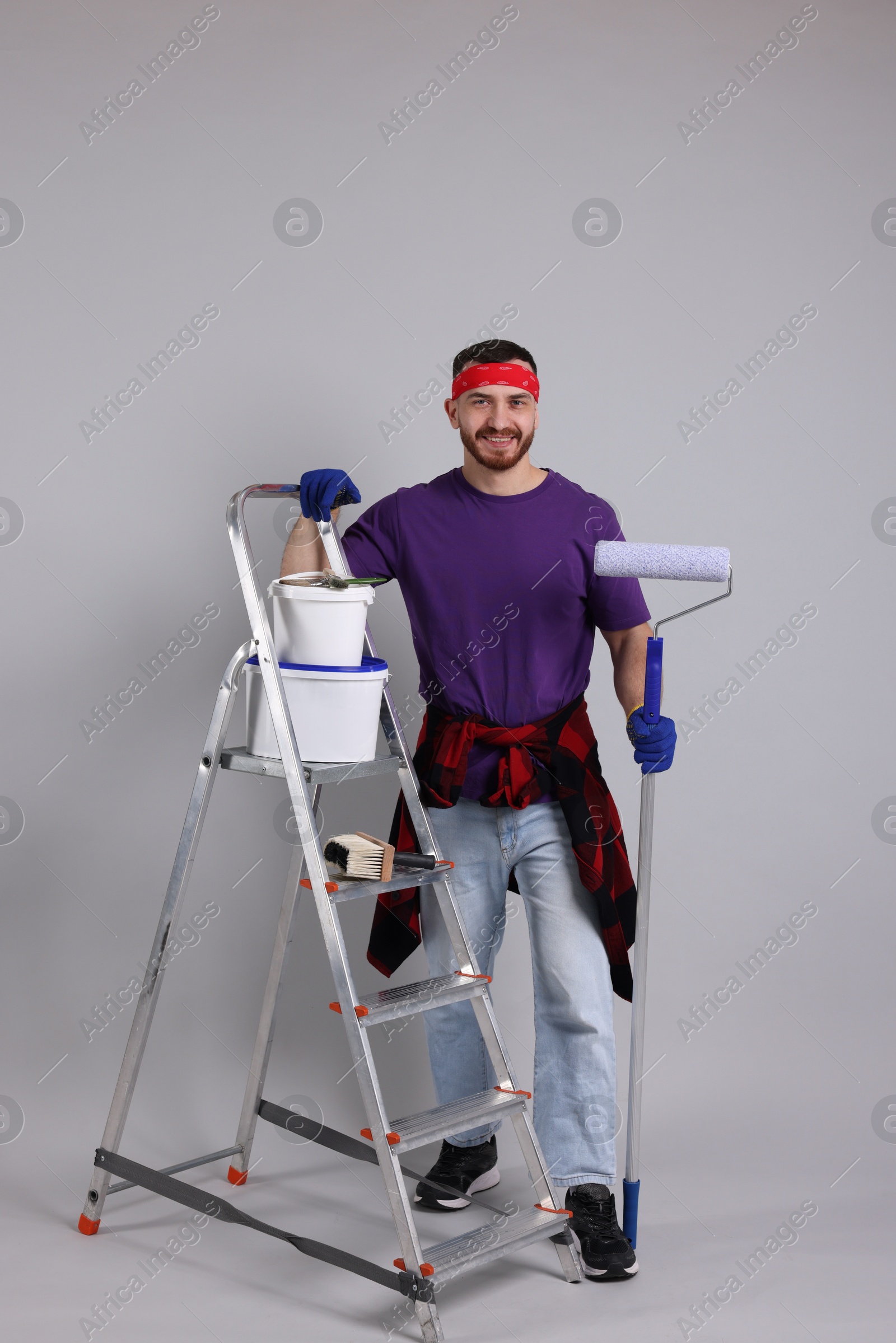 Photo of Man with tools and supplies on light grey background