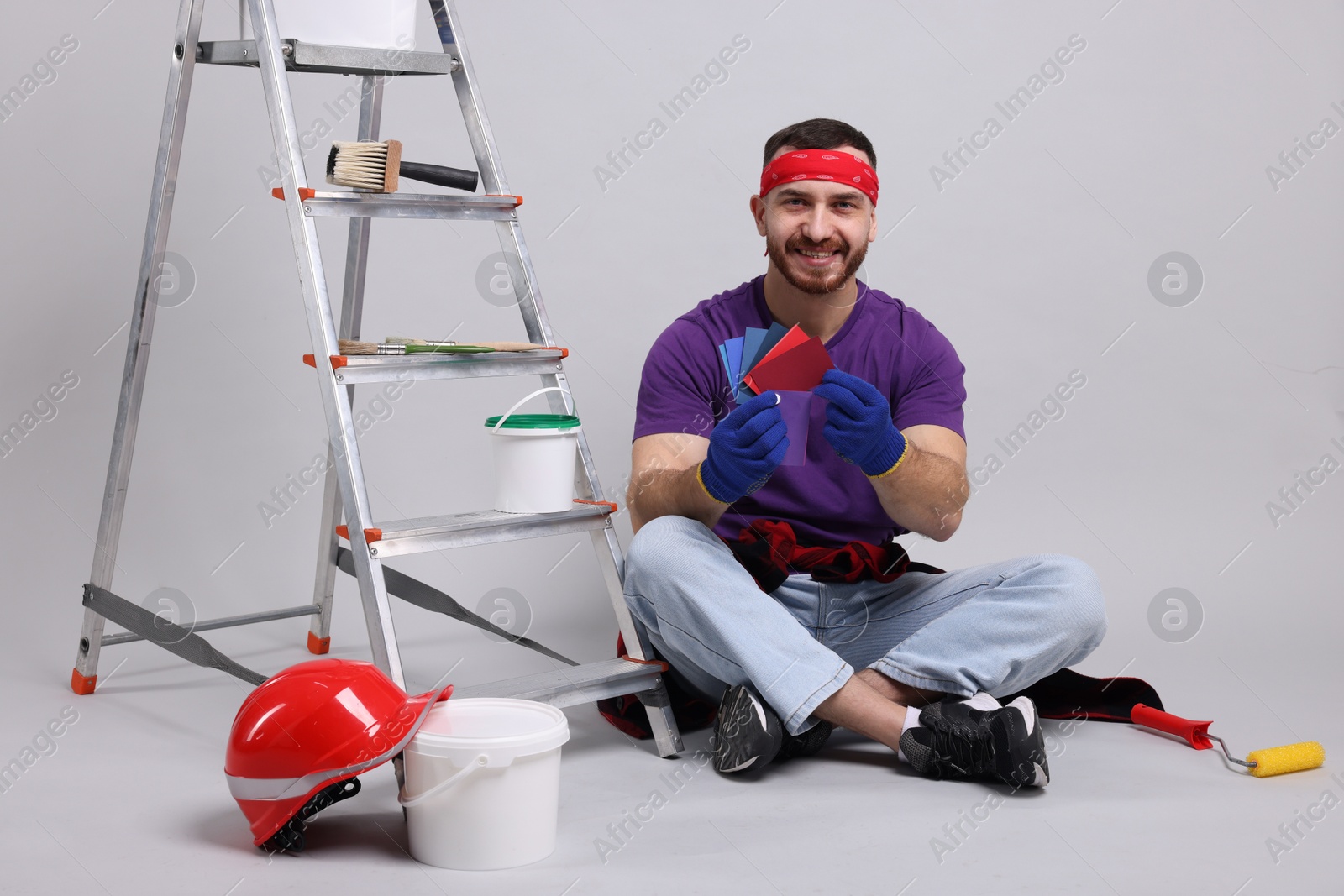 Photo of Man with tools and supplies on light grey background