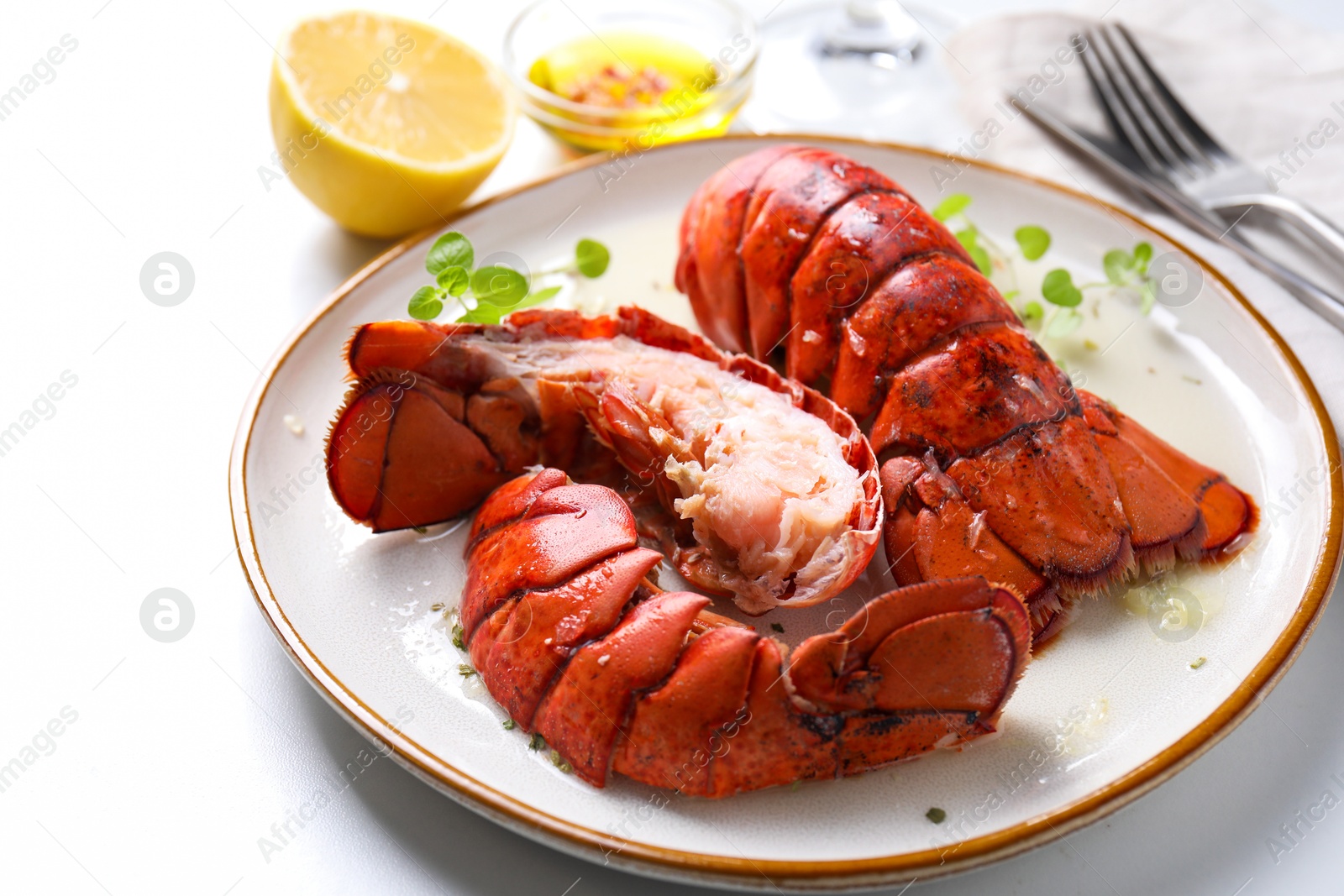 Photo of Delicious tails of boiled lobsters served on white table, closeup