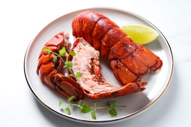 Photo of Delicious tails of boiled lobsters served on white table, closeup