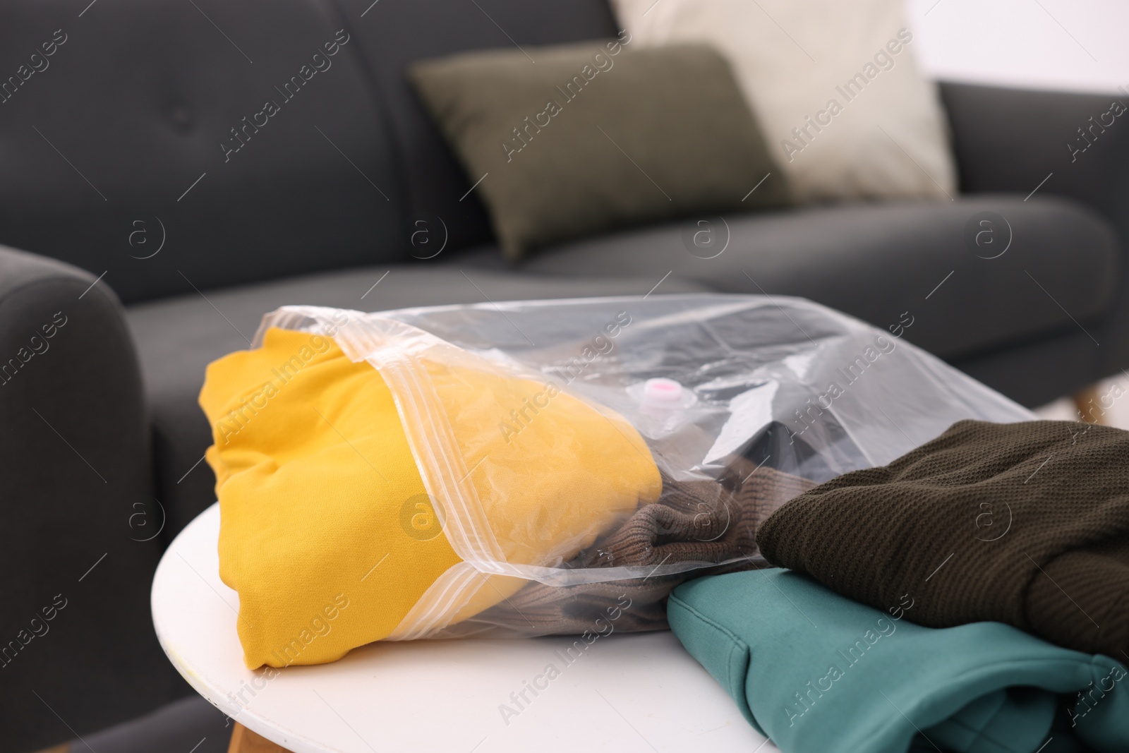 Photo of Clothes and vacuum bag on table at home