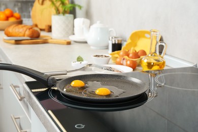 Photo of Cooking tasty eggs on frying pan in kitchen, closeup