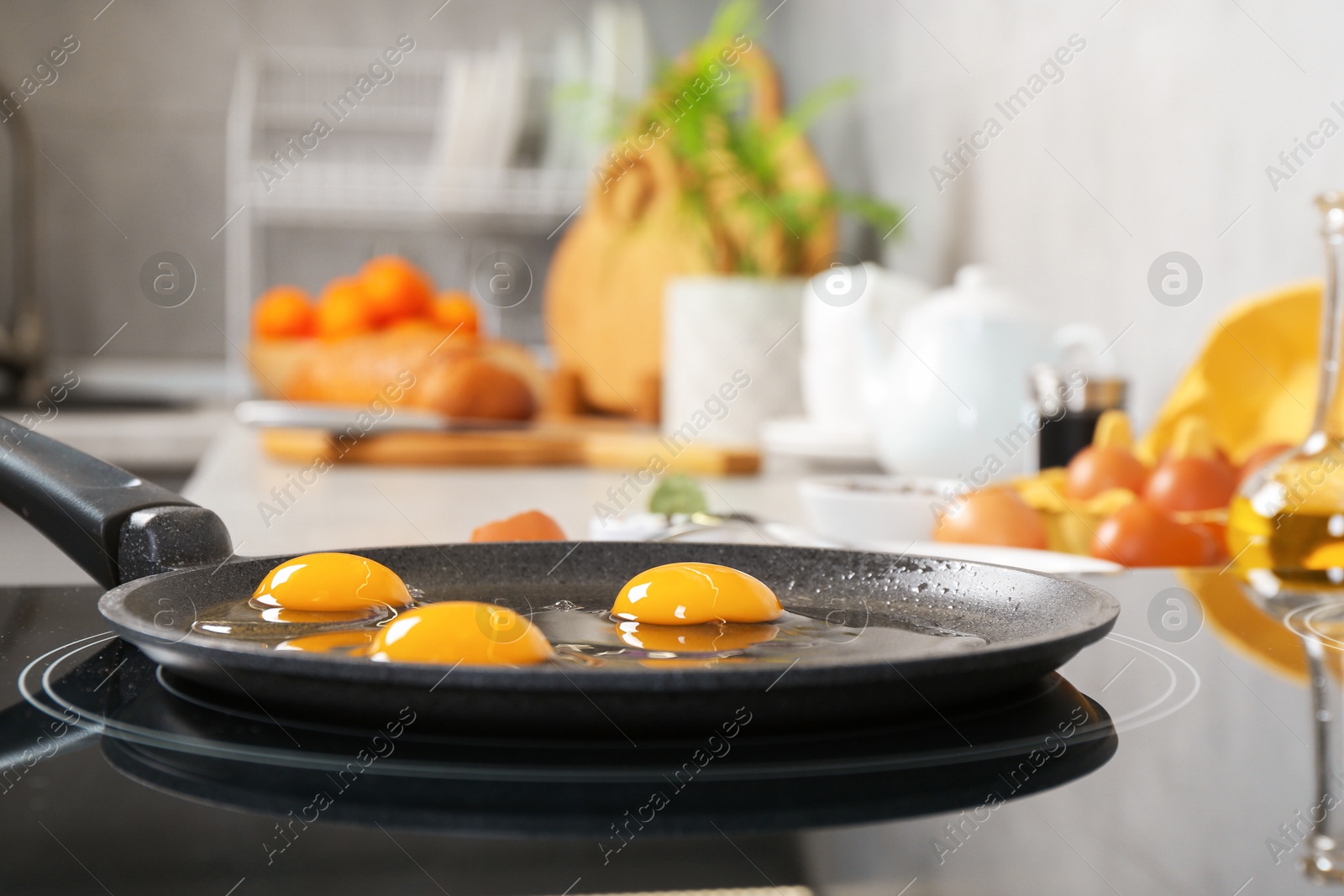 Photo of Cooking tasty eggs on frying pan in kitchen, closeup