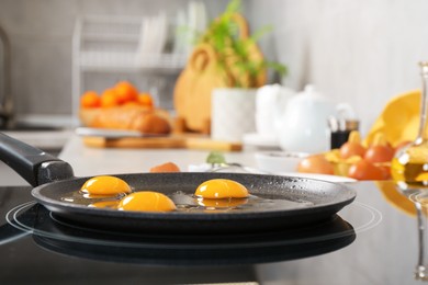 Photo of Cooking tasty eggs on frying pan in kitchen, closeup