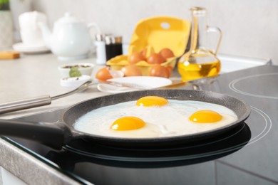 Photo of Cooking tasty eggs on frying pan in kitchen, closeup