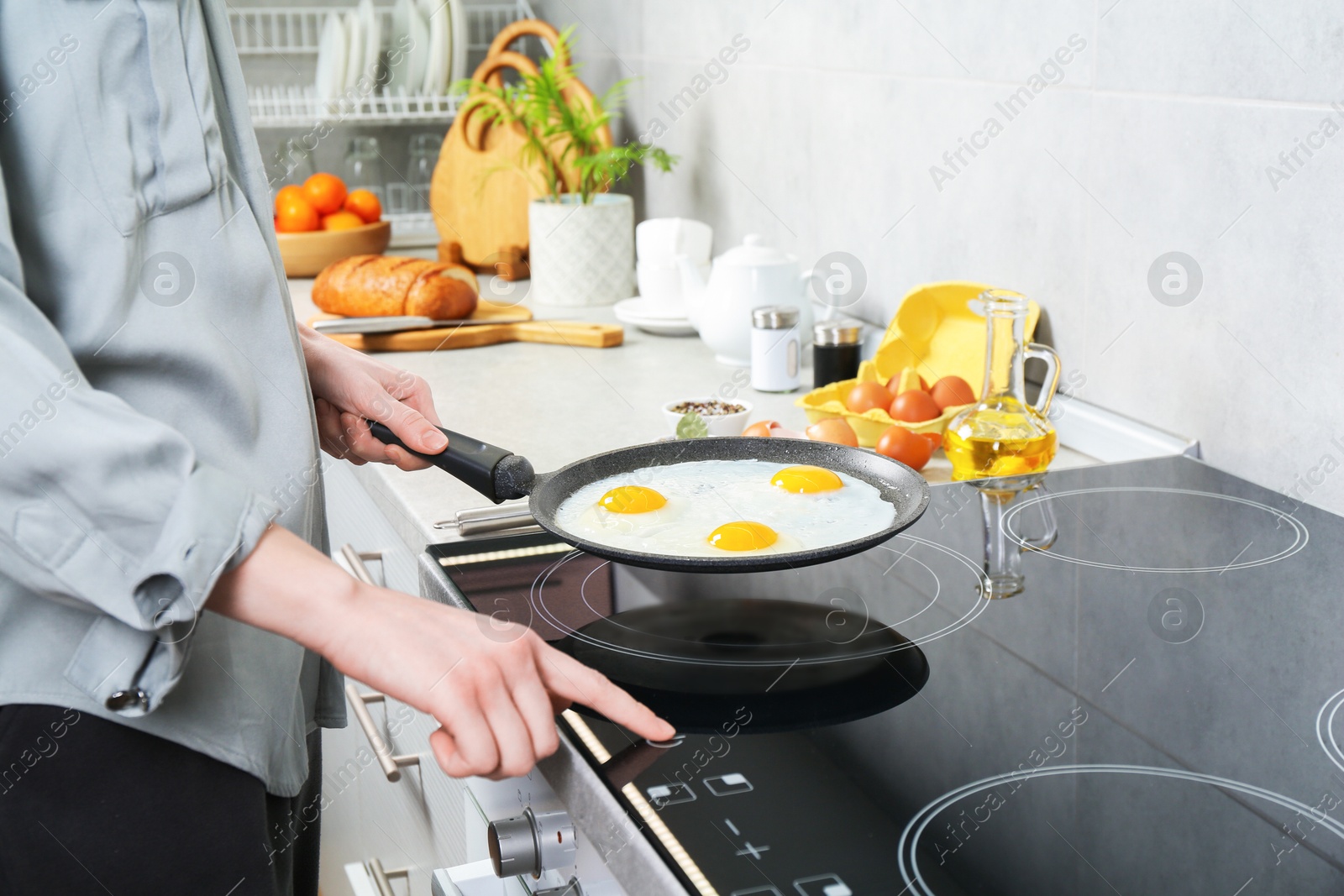 Photo of Woman cooking eggs in frying pan on cooktop indoors, closeup