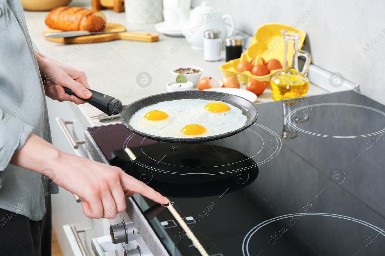 Photo of Woman cooking eggs in frying pan on cooktop indoors, closeup