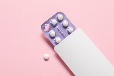 Photo of Blister of oral contraceptive pills on pink background, top view. Space for text