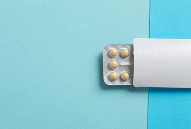 Blister of contraceptive pills in package on light blue background, top view. Space for text