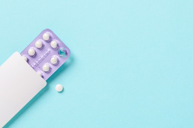 Blister of contraceptive pills in package on light blue background, top view. Space for text