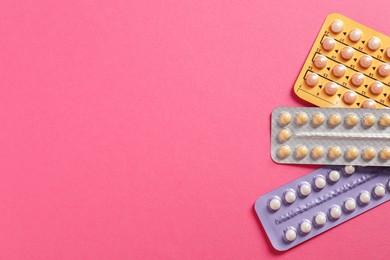 Photo of Blisters of contraceptive pills on pink background, top view. Space for text