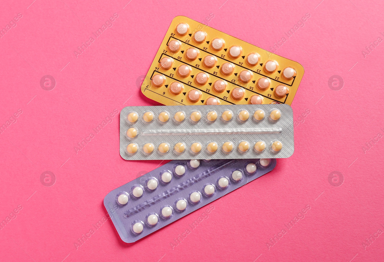 Photo of Blisters of contraceptive pills on pink background, top view