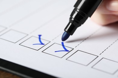 Photo of Woman checking box of paper form, closeup