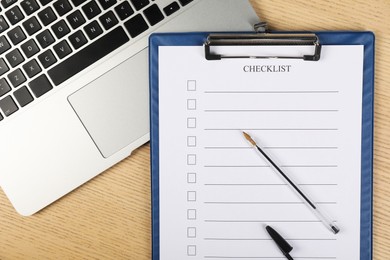 Photo of Checklist with checkboxes, pen and laptop on wooden table, top view